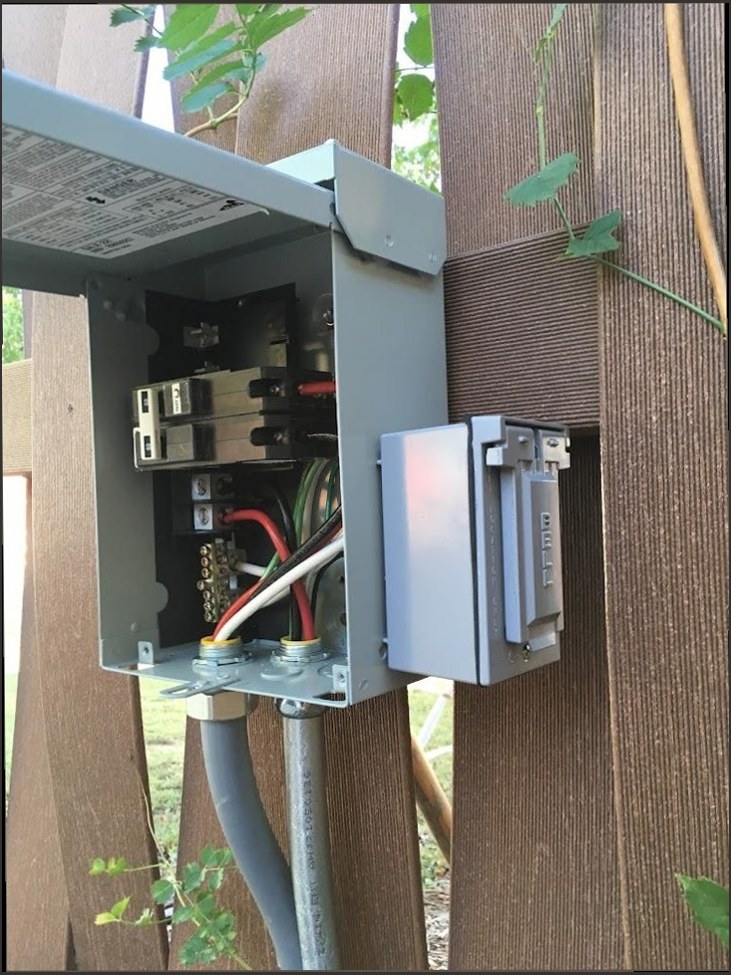 Harrison & Sons Electrical — outdoor sub-panel and disconnect for a backyard hot tub, installed on a composite deck wall